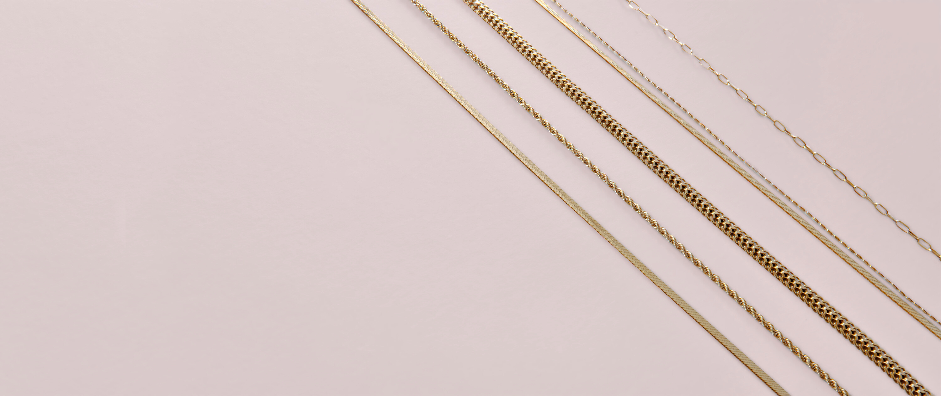 kuusi erilaista kultaista kaulaketjua viistosti vierekkäin 